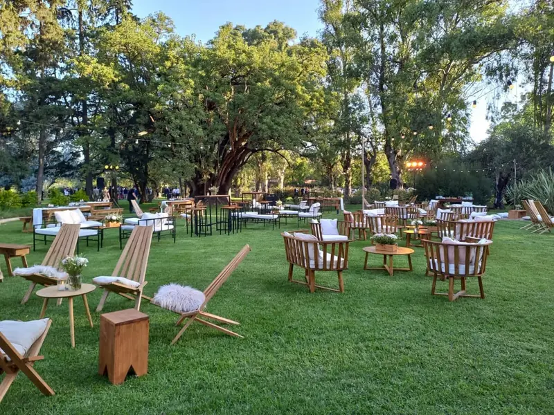 Living armado en el parque con sillones y flores antes de un casamiento