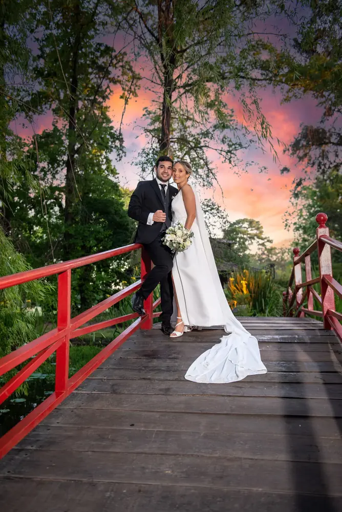 Novios en el puente rojo al atardecer