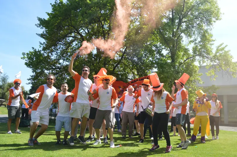 Equipo de una empresa festejando en el parque con bengalas de humo