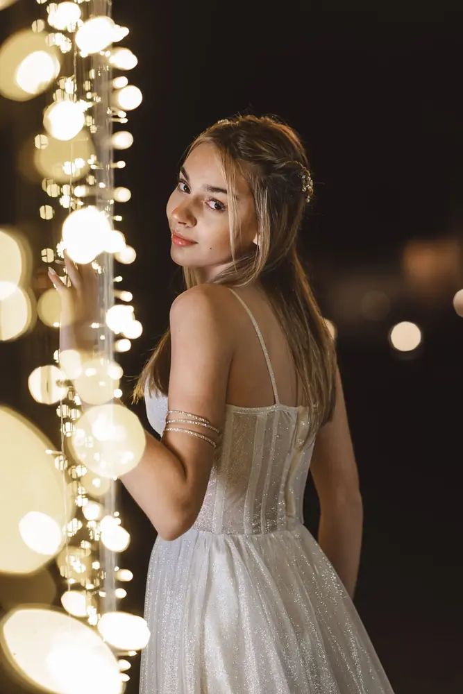 Quinceañera entre luces colgantes